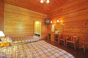 uma cabina de madeira com 2 camas e uma televisão em Da Kuan Peach Farm Resort em Hualing