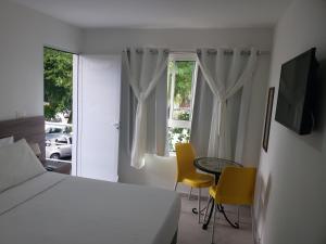 a bedroom with a bed and a table and chairs at Flats Angatu Porto de Galinhas PE in Porto De Galinhas