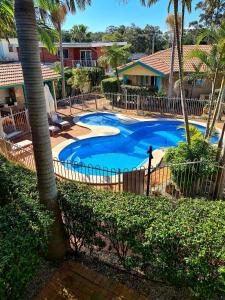 a large blue swimming pool with a fence around it at Beaches Serviced Apartments in Nelson Bay