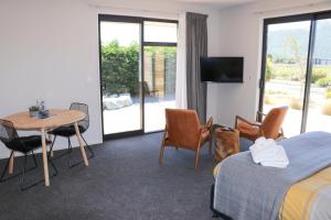 a hotel room with a bed and a table and chairs at Fivestone Suite in Lake Tekapo