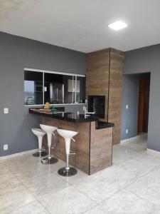 a kitchen with a counter and stools in a room at Minha Casa na Represa Riviera Santa Cristina II in Itaí