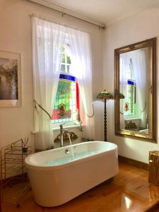 a bath tub in a room with a stained glass window at The Old Eltham Post Office in Eltham