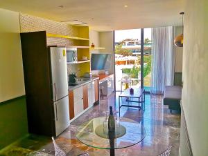 uma cozinha com um frigorífico e uma mesa num quarto em Singular Joy Vacation Rentals em Playa del Carmen