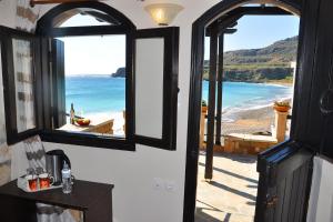 an open door with a view of the beach at Coral Front Beach in Kato Zakros