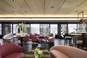 a restaurant with pink chairs and tables and windows at Fauchon Hotel Kyoto in Kyoto