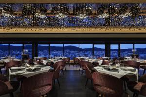 a restaurant with tables and chairs and a view of the city at Fauchon Hotel Kyoto in Kyoto