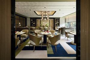 uma sala de jantar com mesas e cadeiras e um lustre em Fauchon Hotel Kyoto - A MEMBER OF THE LEADING HOTELS OF THE WORLD em Quioto