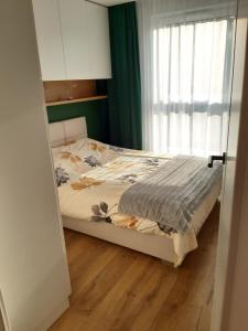 Un pat sau paturi într-o cameră la Apartament Nadmorskie Tarasy z widokiem na morze