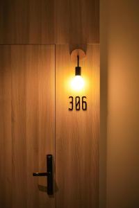 una luz en una puerta de madera con el número en M2 Hotel Waterside, en Phayao