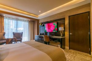 a hotel room with a bed and a television at K Tower Boutique Hotel By Lucerna in Tijuana