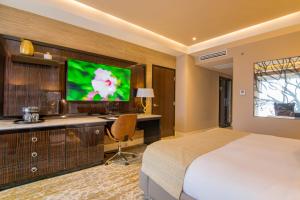 a hotel room with a bed and a tv at K Tower Boutique Hotel By Lucerna in Tijuana