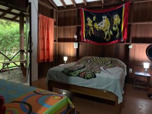 Schlafzimmer mit einem Bett mit einer Fahne an der Wand in der Unterkunft Cabinas Coco Lindo in Ojochal