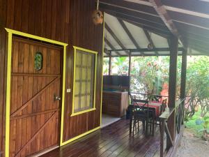 eine offene Tür zu einem Holzhaus mit einem Tisch in der Unterkunft Cabinas Coco Lindo in Ojochal