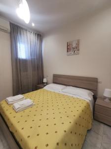 1 dormitorio con 1 cama con colcha amarilla en Green house 2018, en Roma