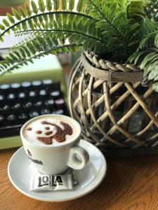 - une tasse de café sur une assiette à côté d'un clavier dans l'établissement Lola Almost Home, à Belgrade