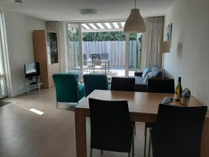 a living room with a dining room table and chairs at Aanloop 34 in Domburg