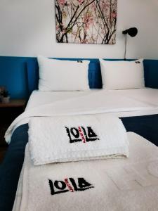 ein Schlafzimmer mit 2 Betten und Handtüchern darauf in der Unterkunft Lola Almost Home in Belgrad