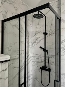 a shower in a bathroom with white marble at Valkenhof in Valkenburg