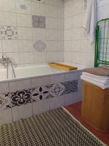 a bathroom with a bath tub and a sink at Kamienna Chata in Urowo
