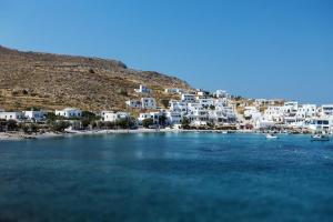 a group of white houses on a hill next to the water at Family house by the seaside of Karavostasis in Karavostasi