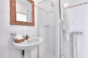 a white bathroom with a sink and a mirror at Soggiorno Isabella De' Medici in Florence +34 photos