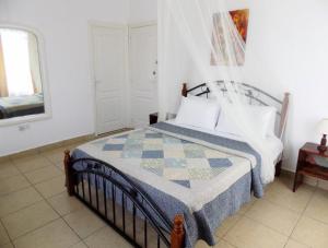 a bedroom with a bed with a quilt on it at Villa Osumare Guest House in Flic-en-Flac