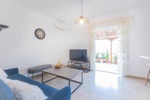 Penthouse Project – Rooftop Chasers Ideal في أثينا: غرفة معيشة مع أريكة زرقاء وتلفزيون