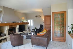 Una sala de estar con un sofá y una chimenea. en Au Grand Bonheur, en Bessèges