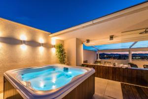 uma banheira de hidromassagem no meio de um quarto em Penthouse with roof terrace with jacuzzi em Zadar