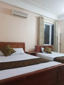 een hotelkamer met 2 bedden en een raam bij Viet Thanh Hotel in Ha Long