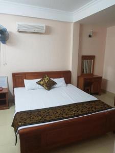 een slaapkamer met een bed met een kussen erop bij Viet Thanh Hotel in Ha Long