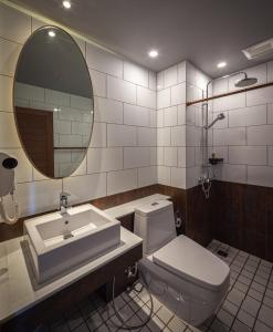 a bathroom with a sink and a toilet and a mirror at Navakitel Design Hotel in Nakhon Si Thammarat