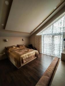 a bedroom with a bed and a large window at Pamir One in Khorog