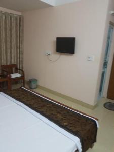 1 dormitorio con 1 cama y TV en la pared en Viet Thanh Hotel, en Ha Long