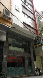 a building with a sign in the window of a store at Viet Thanh Hotel in Ha Long