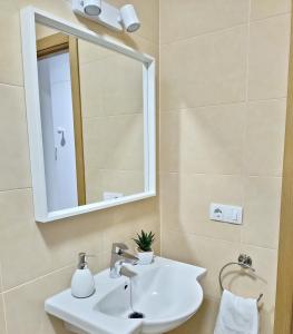 uma casa de banho com um lavatório branco e um espelho. em RELAX CHICLANA-Aparcamiento privado-TV Cable-WifiPlus-Aire Acond-Incluido em Chiclana de la Frontera