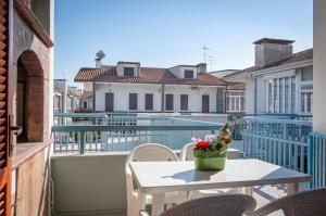 einen Balkon mit einem Tisch, Stühlen und einem Pool in der Unterkunft Masina 45 in Porto Garibaldi