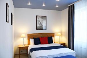 ein Schlafzimmer mit einem Bett und zwei Lampen auf Tischen in der Unterkunft Žalias namas in Palanga