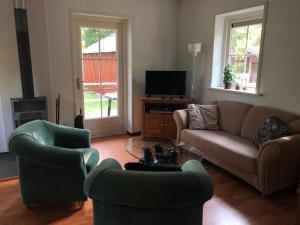 ein Wohnzimmer mit 2 Sofas und einem TV in der Unterkunft Eriksmala villa in Eriksmåla