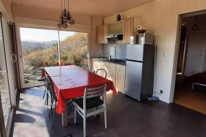 eine Küche mit einem Tisch und einem roten Tischtuch in der Unterkunft MacQuart P.O.A. RANCH Gîte de 2 à 8 pers in Saint-Martin-de-Fugères