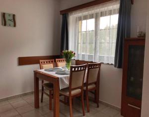 een eettafel met stoelen en een raam bij Apartmán Renáta 10 in Ružomberok