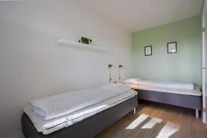 a bedroom with two beds and a mirror at Lindvig - Ferie i naturen in Nymindegab