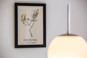 a picture of a flower in a frame next to a lamp at Lindvig - Ferie i naturen in Nymindegab