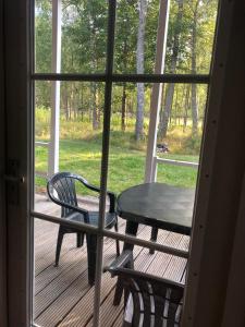 una mesa y una silla en un porche con ventana en Eriksmala villa en Eriksmåla