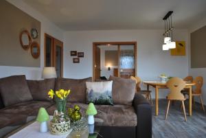 a living room with a couch and a table at Goldener Hahn Residence Ferienwohnungen mit Infrarot Sauna, Panorama Aussicht & Pool, Frühstücksservice im Aparthotel in Baiersbronn
