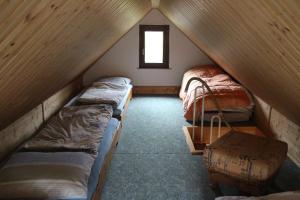 um quarto no sótão com 3 camas e uma janela em Ferienhaus Dani em Bad Gottleuba