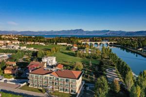 una vista aerea di un resort con un fiume e un ponte di Hotel Rivus a Peschiera del Garda