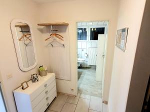 a bathroom with a white dresser and a mirror at Ferienwohnung Baumann in Neupotz +22 photos