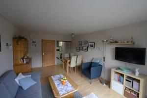 a living room with a blue couch and a table at Ferienhaus Kleine Oase in Varel