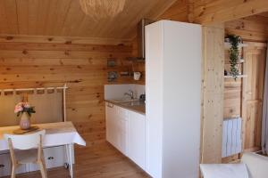 a kitchen with wooden walls and a table in a room at CHALET ESPRIT ZEN et NATURE AVEC SPA in Saint-Hilaire-de-Riez +4 photos